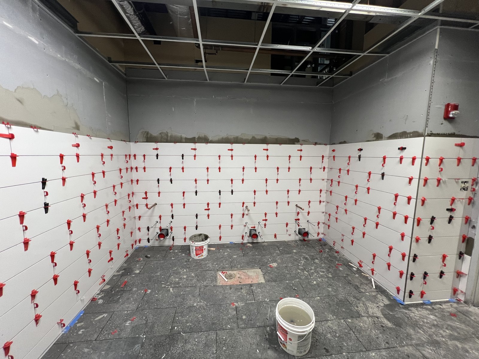 Commercial tile installation with leveling system in progress